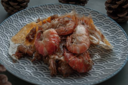 Foto de Tasty appetizing garlic Prawns, Shrimps on frying pan with Fried eggs in a frying on a japanese dish. Oblique view from the top with Copy space. - Imagen libre de derechos