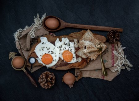 Foto de "Dos huevos fritos con tostadas para un desayuno saludable sobre un hermoso fondo de madera, concepto de nutrición." - Imagen libre de derechos