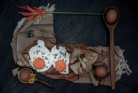 Téléchargez les photos : "Deux œufs frits avec pain grillé pour un petit déjeuner sain sur un beau fond en bois, concept de nutrition." - en image libre de droit