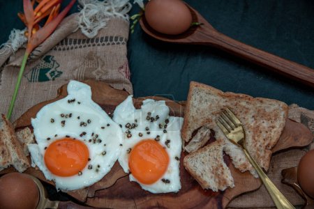 Foto de Dos huevos fritos con tostadas para un desayuno saludable sobre un hermoso fondo de madera, concepto de nutrición - Imagen libre de derechos