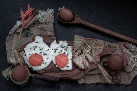 Foto de Dos huevos fritos con tostadas para un desayuno saludable sobre un hermoso fondo de madera, concepto de nutrición - Imagen libre de derechos
