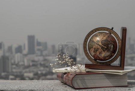Photo for "Journey and Learning concept background. Globe and stack of books with a sky background." - Royalty Free Image
