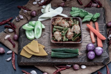 Photo for "Thai food, Stir Fried fish ball with Red Curry Paste and long bean with the ingredient and fresh vegetables on wood background." - Royalty Free Image