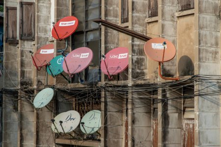 Photo for Many satellite dishes mounted to the outside wall of a residential building. Selective focus. - Royalty Free Image
