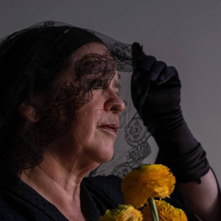 Téléchargez les photos : "Gros portrait de femme en deuil voilée, avec des fleurs jaunes" - en image libre de droit