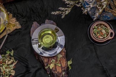 Foto de "A Cup of pandan leaf tea, indian marsh fleabane plant leaves with Safflower dried (Saffron substitute) at dark background." - Imagen libre de derechos