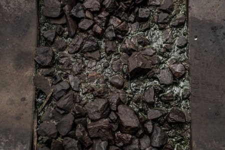 Photo for "Ballast stone gravel soaked with engine oil in the railroad tracks." - Royalty Free Image