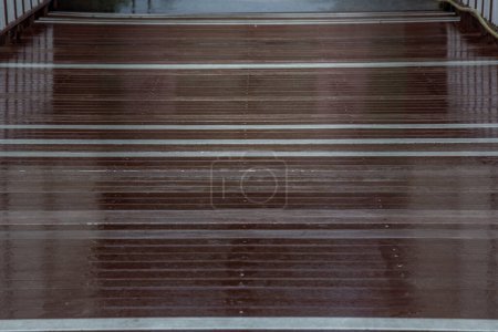 Téléchargez les photos : Gros plan sur le bois Pont sol après pluie avec réflexion des lumières. - en image libre de droit