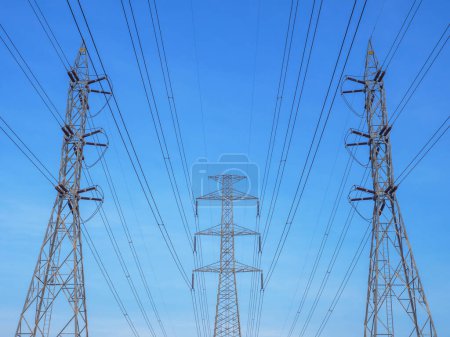 Téléchargez les photos : Vue grand angle des tours de transmission avec ligne électrique au-dessus du ciel bleu et fond nuageux blanc - en image libre de droit