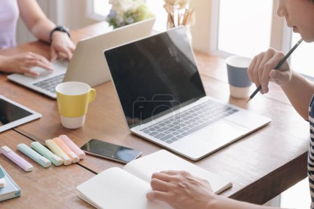 Photo for "Business meeting time. Photo young account managers crew working with new startup project. Notebook on wood table. Idea presentation, analyze plans. " - Royalty Free Image