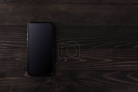 Foto de "smartphone moderno en mesa de madera negra" - Imagen libre de derechos