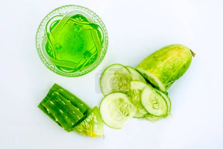 Photo for "Raw cucumber along with some aloe vera gel well mixed in a glass bowl isolated on white entire ingredients.Used to rejuvenate your skin and for instant glow." - Royalty Free Image