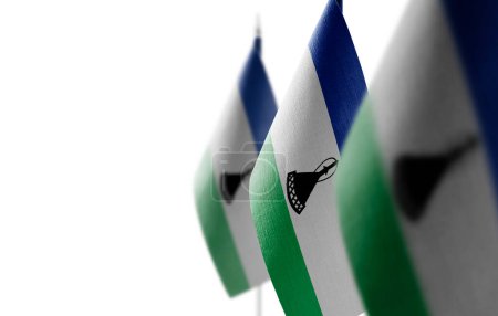 Foto de "Pequeñas banderas nacionales del Lesotho sobre un fondo blanco" - Imagen libre de derechos
