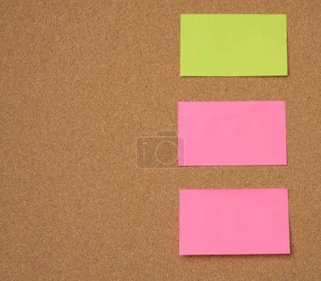 Téléchargez les photos : Bâtons de papier multicolores collés sur le carton de liège brun - en image libre de droit