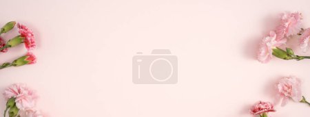 Téléchargez les photos : Concept design de fête des mères accueil avec bouquet d'oeillets sur fond de table rose - en image libre de droit