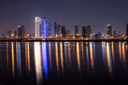 Foto de "30 dic 2020, Dubai, Emiratos Árabes Unidos. Vista panorámica del horizonte de Sharjah con apartamentos, hoteles y rascacielos capturados en la playa Mamzar, Dubai Emiratos Árabes Unidos en un día nublado." - Imagen libre de derechos