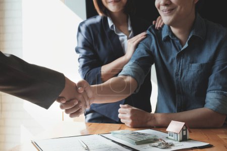 Photo for "Young Asian Couple shaking hands with Estate agent after contract signature. Real Estate concept." - Royalty Free Image