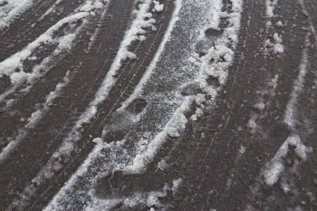 Téléchargez les photos : "Pneus dans la neige fondante sur route asphaltée" - en image libre de droit