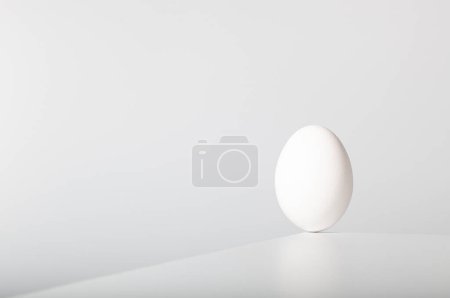 Foto de El huevo blanco se equilibra en el borde - Imagen libre de derechos
