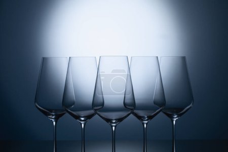 Photo for "Empty wine glasses on a blue clean gradient background. " - Royalty Free Image