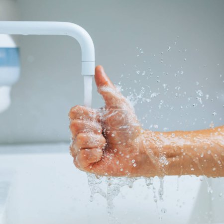 Foto de Pulgar hacia arriba la mano bajo el grifo de la batidora con agua corriente - Imagen libre de derechos