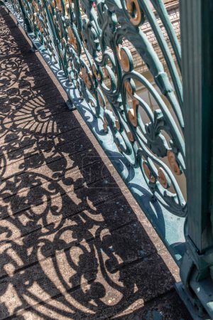 Téléchargez les photos : "Clôture décorative en fer forgé sur pont et ombre." - en image libre de droit