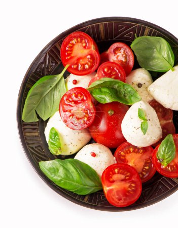 Photo for Round camembert cheese with cherry tomatoes and basil in a dark plate - Royalty Free Image