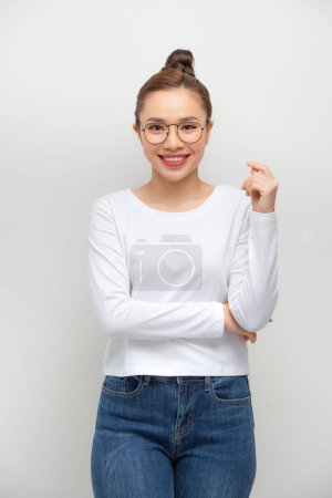 Foto de Simple retrato de una chica asiática con los brazos cruzados sobre fondo blanco
. - Imagen libre de derechos