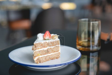 Photo for "Carrot cake with strawberries topping on table." - Royalty Free Image