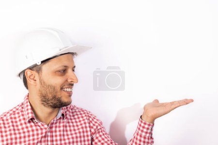 Foto de "Obrero constructor guapo con casco blanco mostrando sus manos
" - Imagen libre de derechos