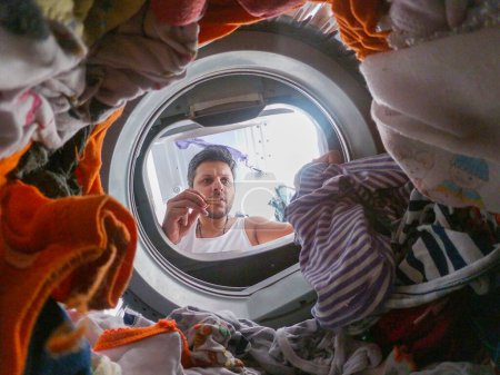 Foto de Barbudo hombre usando lavadora en casa - Imagen libre de derechos