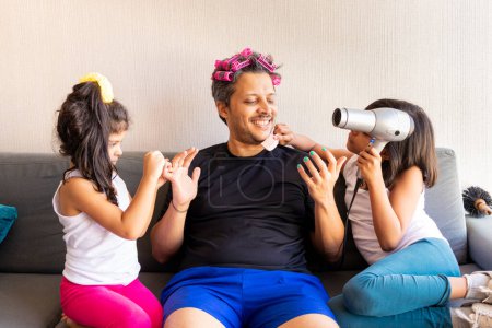 Téléchargez les photos : Jolies filles peignent les ongles et peignent les cheveux de leur beau jeune père - en image libre de droit