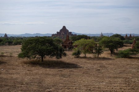 Téléchargez les photos : Plusieurs temples dans la distance d'un champ d'herbe sèche ouverte - en image libre de droit