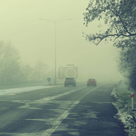 Photo for Cars in the fog. Bad winter weather and dangerous automobile traffic on the road. Vehicles in fog. - Royalty Free Image