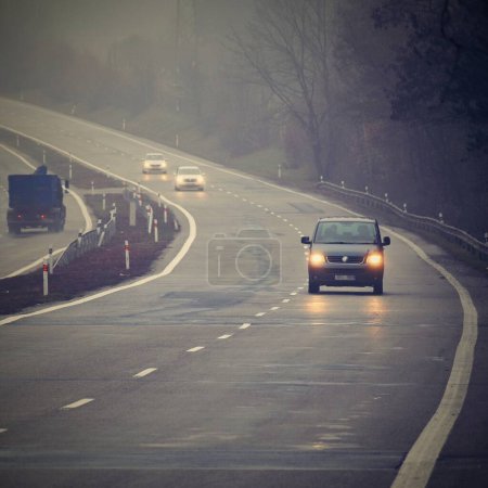 Photo for Bad weather driving - foggy hazy country road. Motorway - road traffic. Winter time. - Royalty Free Image