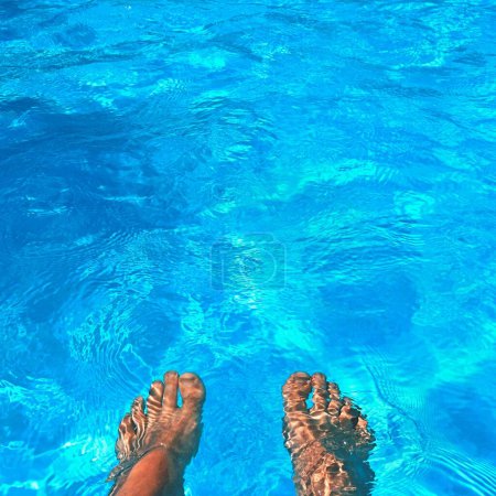 Téléchargez les photos : Jambes dans la piscine avec de l'eau propre. Fond d'été pour voyager
. - en image libre de droit
