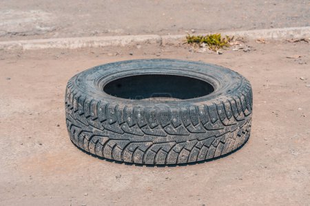 Foto de Un desgastado neumático de invierno arrojado a la carretera - Imagen libre de derechos