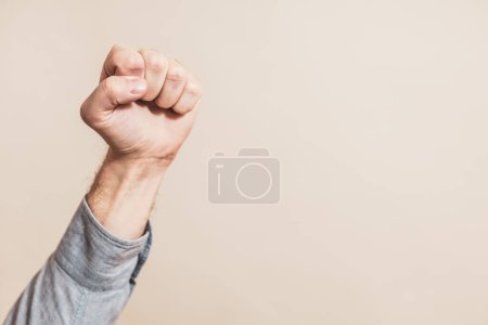 Téléchargez les photos : Image of male fist on beige background - en image libre de droit