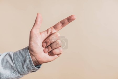 Téléchargez les photos : Main masculine pointant sur fond beige - en image libre de droit