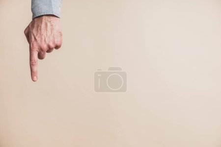 Foto de Mano masculina apuntando sobre fondo beige - Imagen libre de derechos