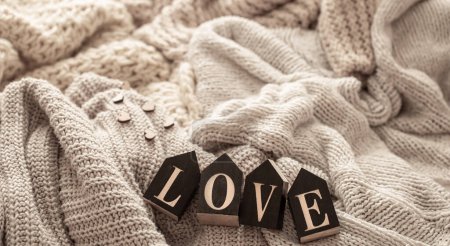 Foto de Cozy composition with knitted elements and wooden decorative word love. - Imagen libre de derechos