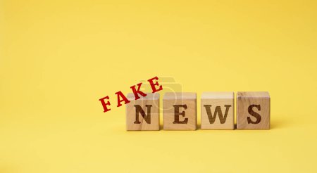 Photo for Wooden cubes with the inscription false news on a yellow background. The concept of information hygiene, propaganda, debunking of myths and false information - Royalty Free Image