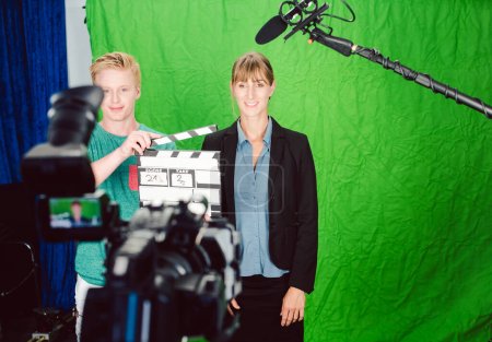 Téléchargez les photos : Production vidéo dans un studio de salle verte avec caméra, équipe et micro - en image libre de droit