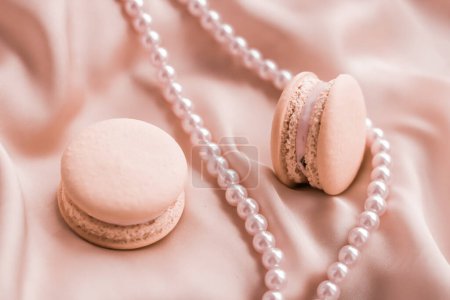 Téléchargez les photos : "Bijoux macarons et perles sucrés sur fond soie, bijoux chic parisien, dessert français et gâteau macaron pour la marque de confiserie de luxe, cadeau de vacances" - en image libre de droit