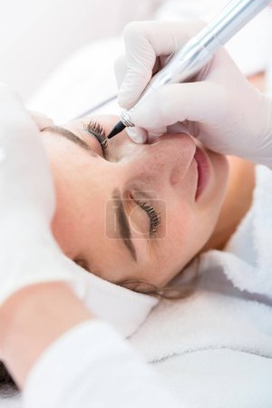 Photo for Woman in beauty salon for eyebrow treatment - Royalty Free Image