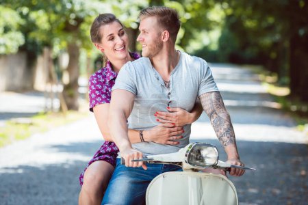Photo for "Happy couple riding on old scooter" - Royalty Free Image