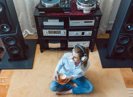 Photo for Woman listening to music from a Hi-Fi stereo - Royalty Free Image