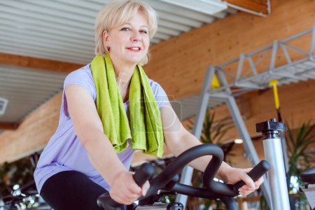 Photo for Senior woman on an exercise bike in the gym - Royalty Free Image