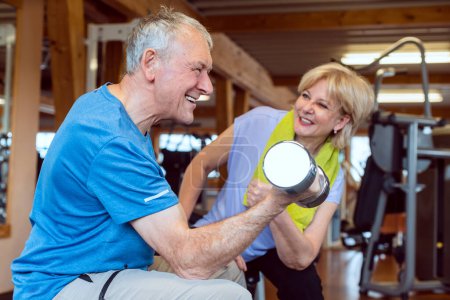 Téléchargez les photos : Senior homme faisant haltère exercice dans la salle de gym - en image libre de droit