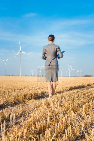 Téléchargez les photos : Investisseuse en énergie verte regardant ses éoliennes - en image libre de droit